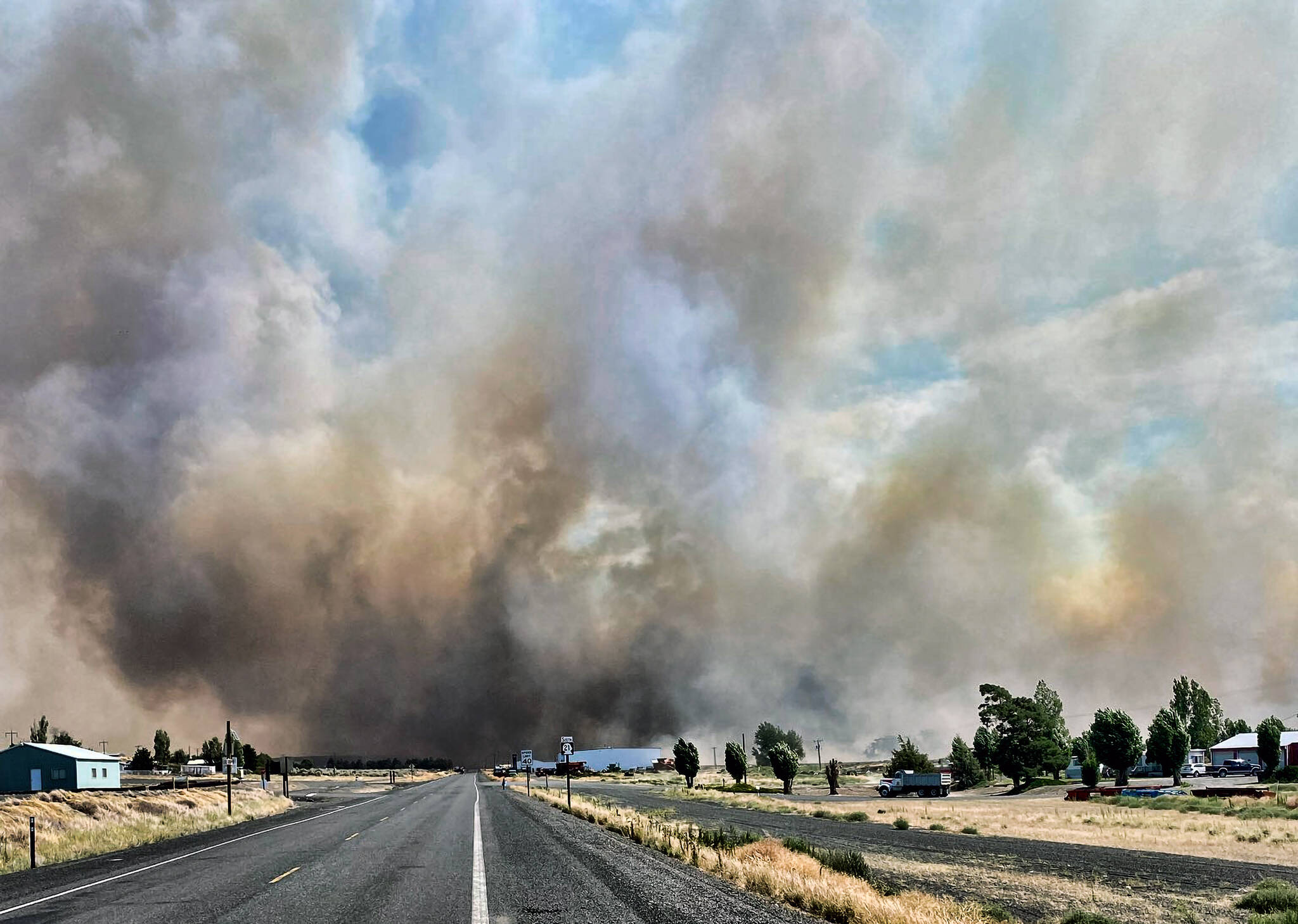 This photo provided by the Washington State Department of Transportation shows smoke from a wildfire burning south of Lind, Wash., on Thursday, Aug. 4, 2022. Sheriff’s officials are telling residents in the Eastern Washington town to evacuate because of a growing wildfire south of town that was burning homes. (Courtesy photo)