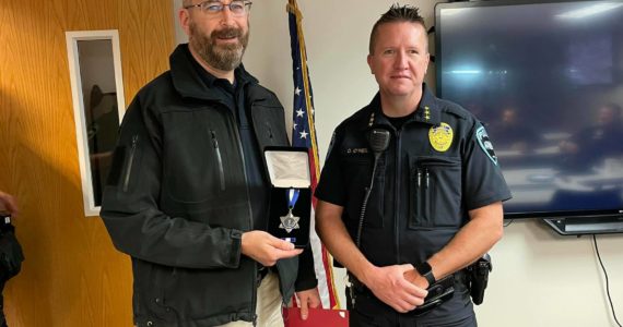 Auburn Police Detective Jon Postawa, left, receives the Auburn Police Department’s Lifesaving Medal from former Police Chief Dan O’Neil, given in recognition of his donation of a kidney to save the life of fellow Auburn Police Detective Damon Hewin. Photo courtesy of Auburn Police Department.