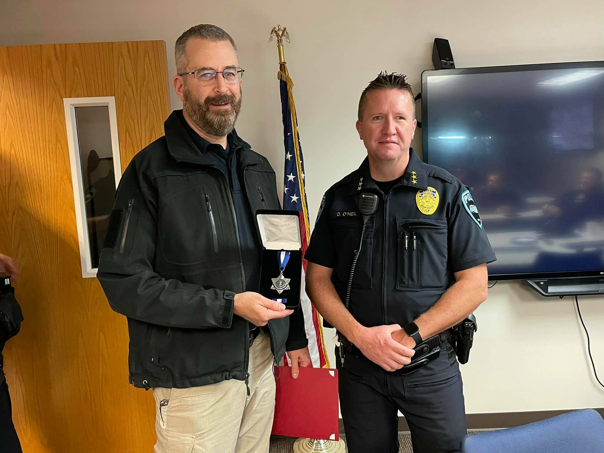 Auburn Police Detective Jon Postawa, left, receives the Auburn Police Department’s Lifesaving Medal from former Police Chief Dan O’Neil, given in recognition of his donation of a kidney to save the life of fellow Auburn Police Detective Damon Hewin. Photo courtesy of Auburn Police Department.