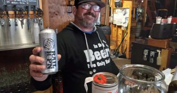 Billy Jack Newman proudly displays Rail Hop n Brewing’s signature drink and his own creation, jalapeno beer. Photo by Robert Whale, Auburn Reporter.
