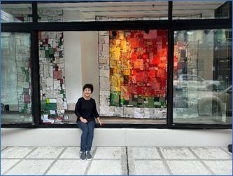 Courtesy photo 
Bella Kim is dwarfed by a display of her recyclable artwork.