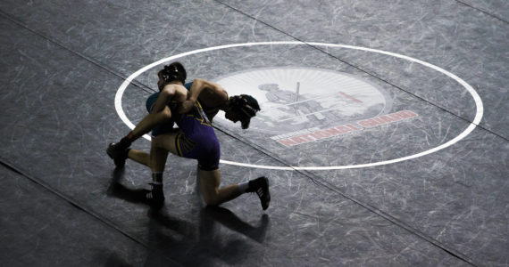 Wrestlers are silhouetted against a black wrestling mat during the Mat Classic XXXIII on Feb. 19, 2022, in Tacoma, Washington. (Olivia Vanni / Sound Publishing)