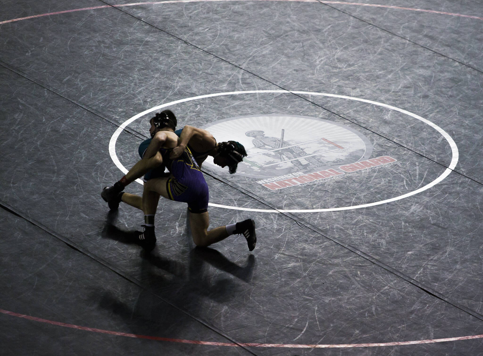 Wrestlers are silhouetted against a black wrestling mat during the Mat Classic XXXIII on Feb. 19, 2022, in Tacoma, Washington. (Olivia Vanni / Sound Publishing)