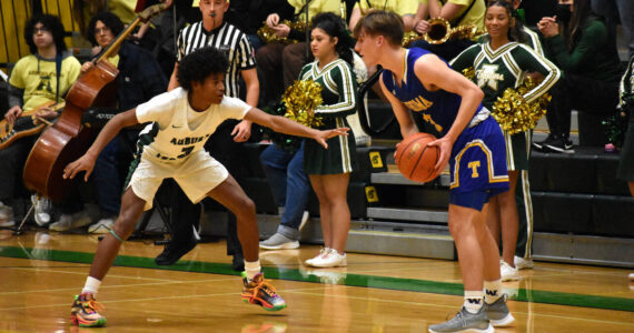 Trojan sophomore Jaylen Petty looks to lockdown Tahoma senior Kevin Williams. Photo by Ben Ray/Sound Publishing
