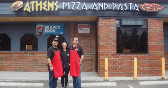 Pictured left to right: Bill, Nina and Tom Contoravdis, co-owners of Athens Pizza and Pasta, pose for a photo in front of their restaurant that is set to re-open for take-out on Friday, April 1. (File photo)
