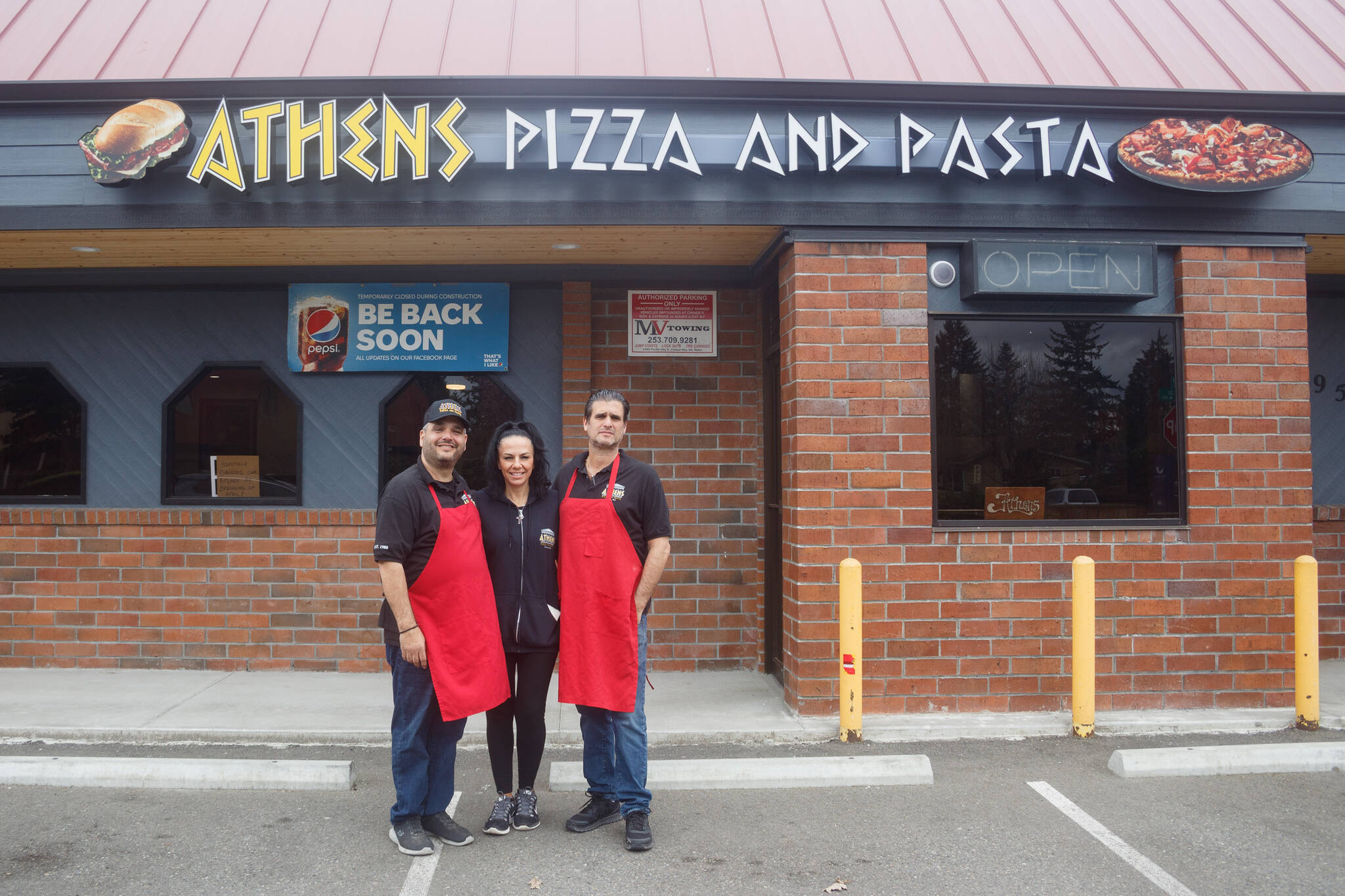 Pictured left to right: Bill, Nina and Tom Contoravdis, co-owners of Athens Pizza and Pasta, pose for a photo in front of their restaurant that is set to re-open for take-out on Friday, April 1. (File photo)