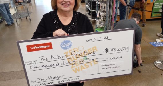 Auburn Food Bank director Debbie Christian is all smiles as she holds a replica of the $50,000 check given to the Auburn Food Bank by the Auburn Fred Meyer store. It was the store’s entire bonus from the Washington State Lottery for selling the winning ticket in the recent Powerball jackpot. Photo by Robert Whale, Auburn Reporter.