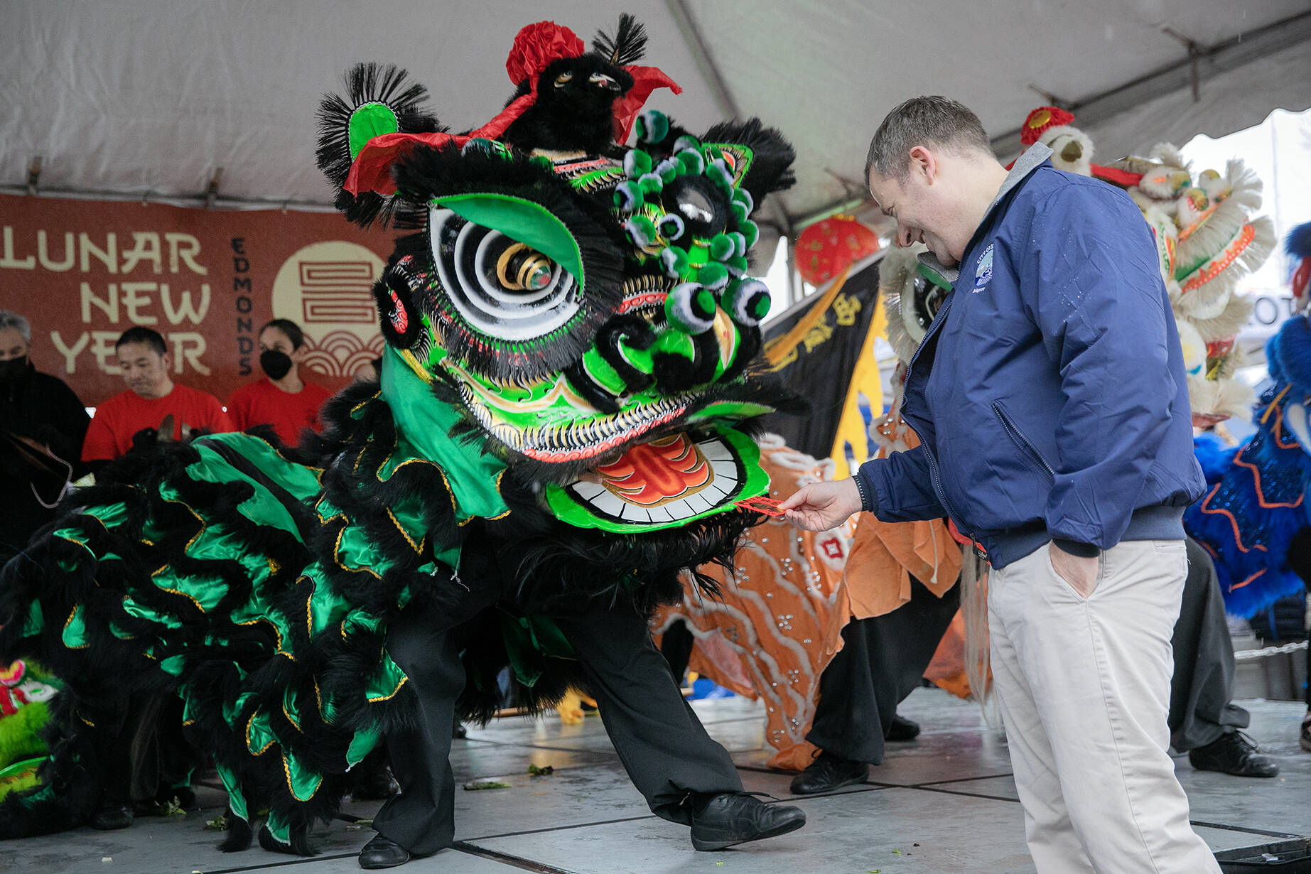 Photo by Ryan Berry / The Herald
Edmonds Mayor Mike Nelson rewards a lion dancer with a traditional red envelope during a celebration of the Lunar New Year on Saturday, Jan. 21, 2023.