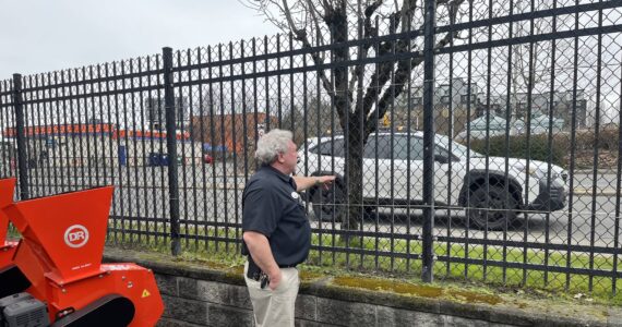 Darren Jones, owner of the AgriShop Ace Hardware in Auburn, checks out wrought iron fencing on the perimeter of the property. (Photo by Ben Leung/Auburn Reporter)