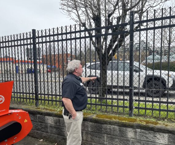 Darren Jones, owner of the AgriShop Ace Hardware in Auburn, checks out wrought iron fencing on the perimeter of the property. (Photo by Ben Leung/Auburn Reporter)
