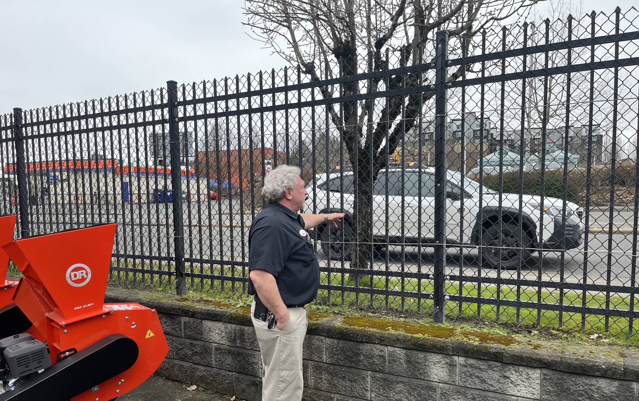 Darren Jones, owner of the AgriShop Ace Hardware in Auburn, checks out wrought iron fencing on the perimeter of the property. (Photo by Ben Leung/Auburn Reporter)