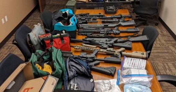 Law enforcement seized approximately 19 firearms, 3,372 grams of suspected methamphetamine, 1,322 grams of suspected fentanyl-laced pills, and over $210,000 in United States currency. (Courtesy of the Department of Justice)