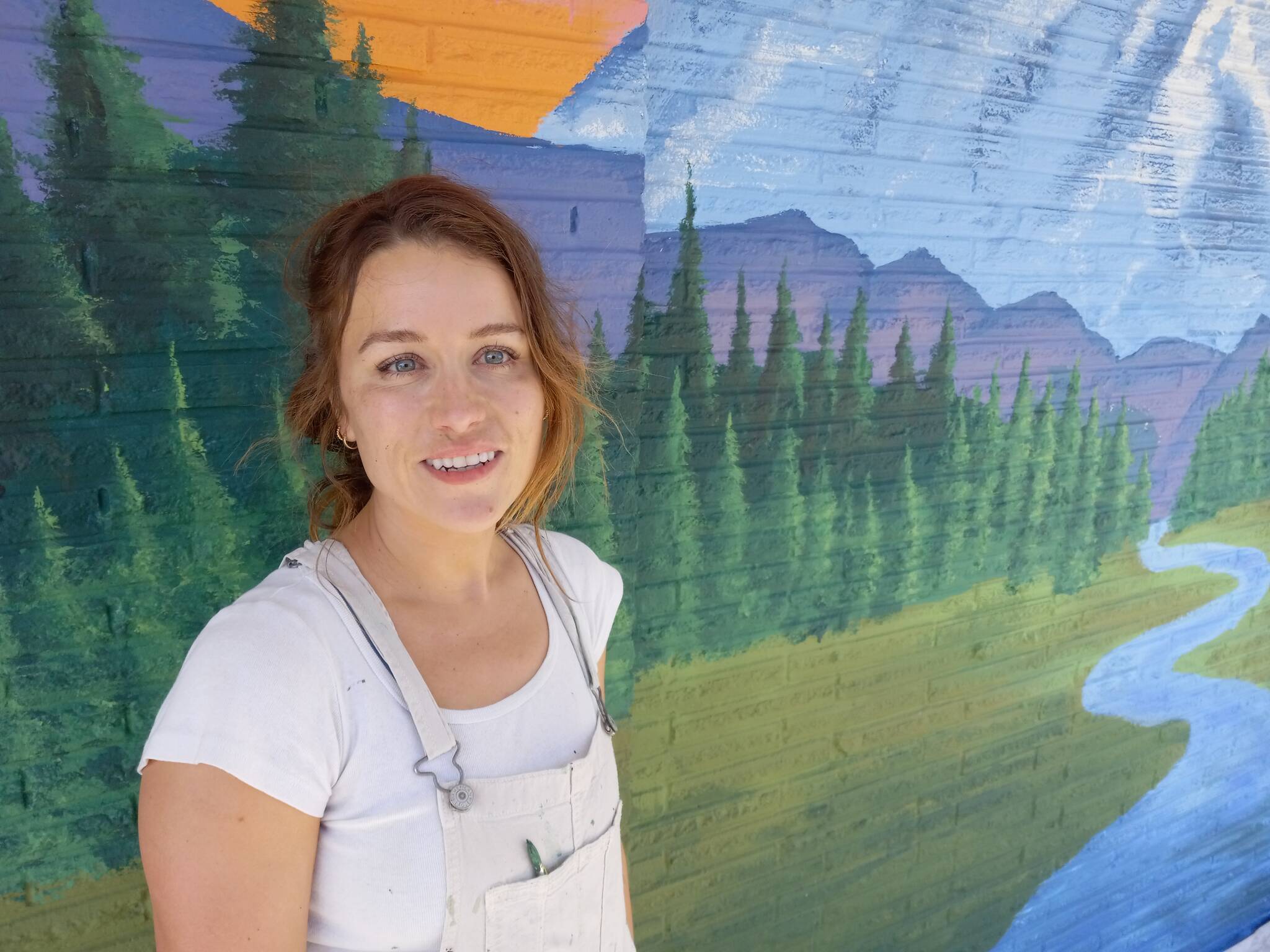 Cody Esp in front of the mural she is painting on the building at East Main and 2 Auburn Way North. Photo by Robert Whale, Auburn Reporter.