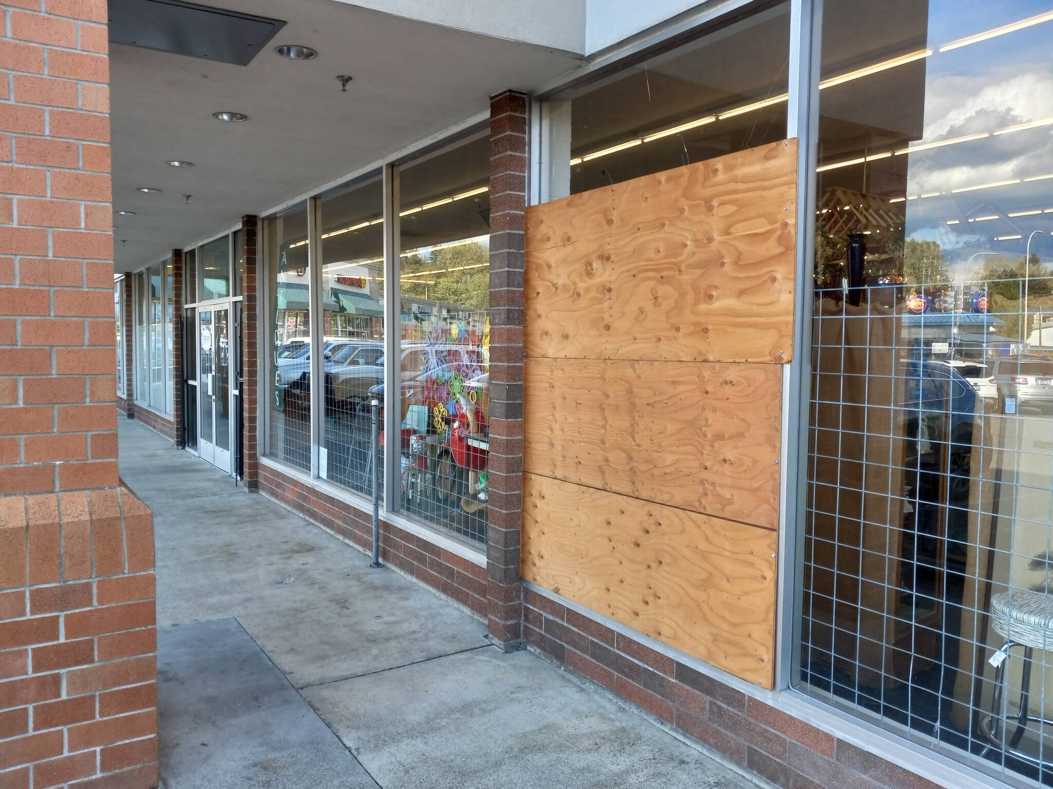 Carly Willis, owner of Antique Marketplace on Howard Road, has left the plywood up on her burglary-shattered window because she said it’s not worth fixing, given the numerous break-ins her business has suffered recently. Photo by Robert Whale, Auburn Reporter.