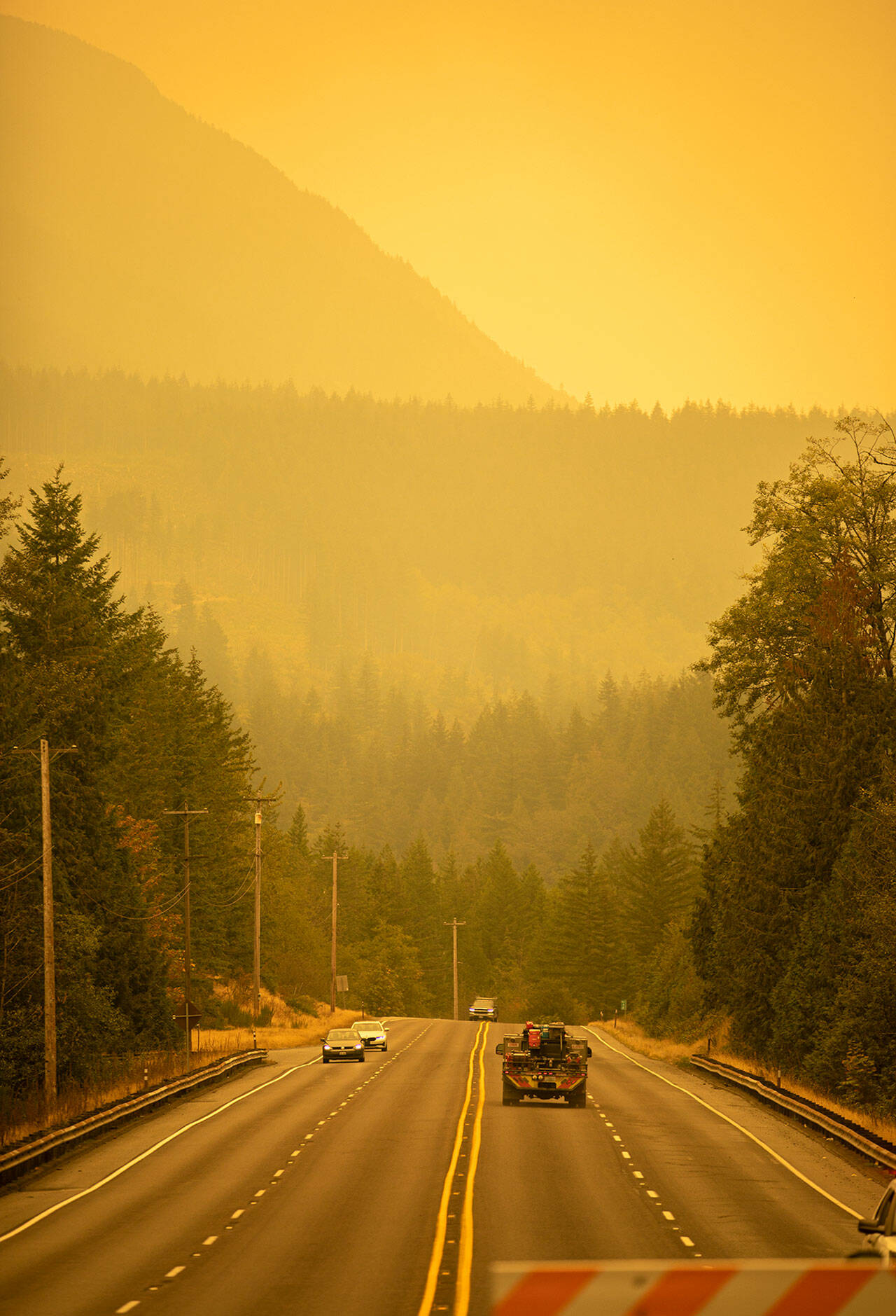 An emergency fire vehicle heads past a barricade and toward Index as numerous agencies attempt to contain the Bolt Creek fire on Saturday, Sep. 10, 2022, on U.S. Highway 2 near Index, Washington. (Photo by Ryan Berry / Sound Publishing)