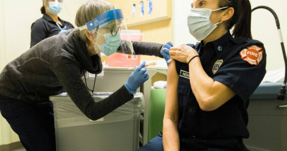 Public Health – Seattle & King County staff administering COVID-19 vaccine to a local emergency responder. COURTESY PHOTO, Public Health-Seattle & King County