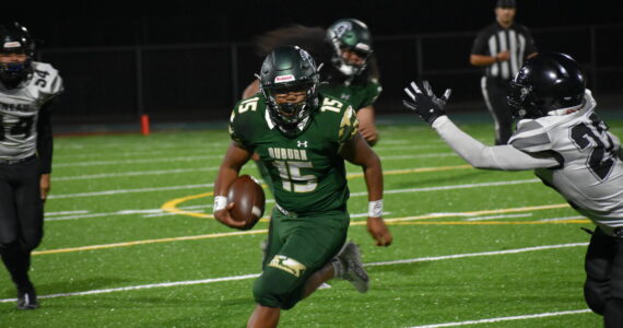 Trojan QB DJ Bielza tries to avoid a defender. Ben Ray / The Reporter