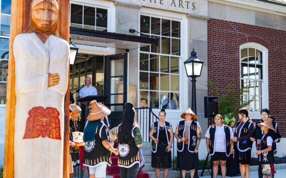 The Muckleshoot Indian Tribe unveil their gift of a Welcome Figure and provide a song and blessing during the Postmark Center for the Arts grand opening. The figure was created by Muckleshoot artists Sam Obrovac, Tyson Simmons and Keith Stevenson. Photo courtesy of City of Auburn