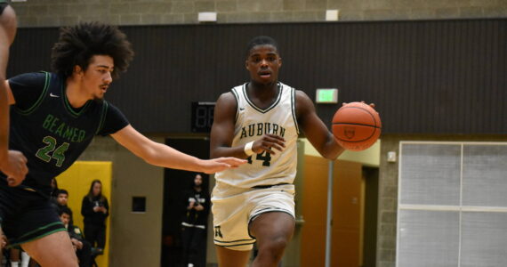 Trojan senior Luvens Valcin dribbles the ball for the Auburn High School. Ben Ray / The Reporter