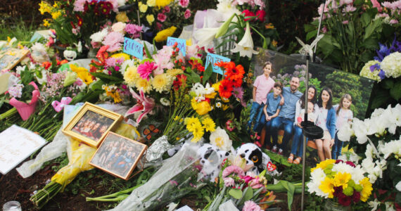 Flowers, framed photos, plush toys and a QR code to the GoFundMe pages of the families grace the memorial site after the March 19 crash. Photo by Bailey Jo Josie/Sound Publishing.