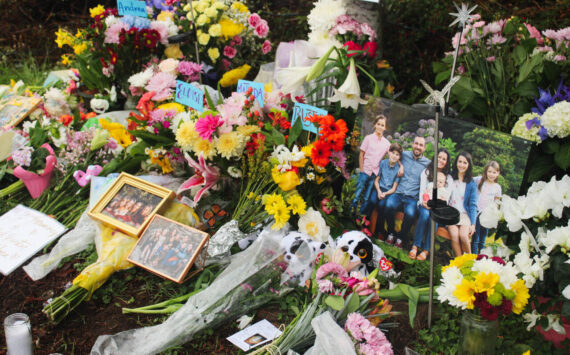 Flowers, framed photos, plush toys and a QR code to the GoFundMe pages of the families grace the memorial site after the March 19 crash. Photo by Bailey Jo Josie/Sound Publishing.