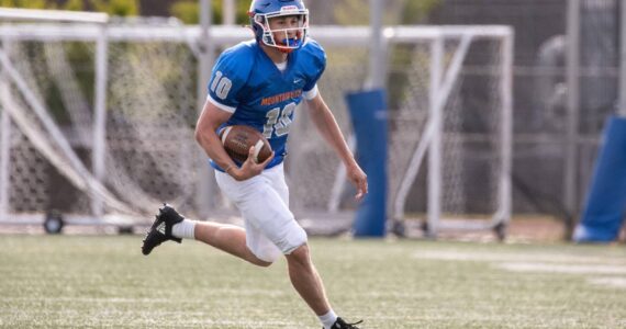 Elijah Baird runs the ball during the Lions scrimmage at Curtis High School. Photo courtesy of Maria Dorsten.