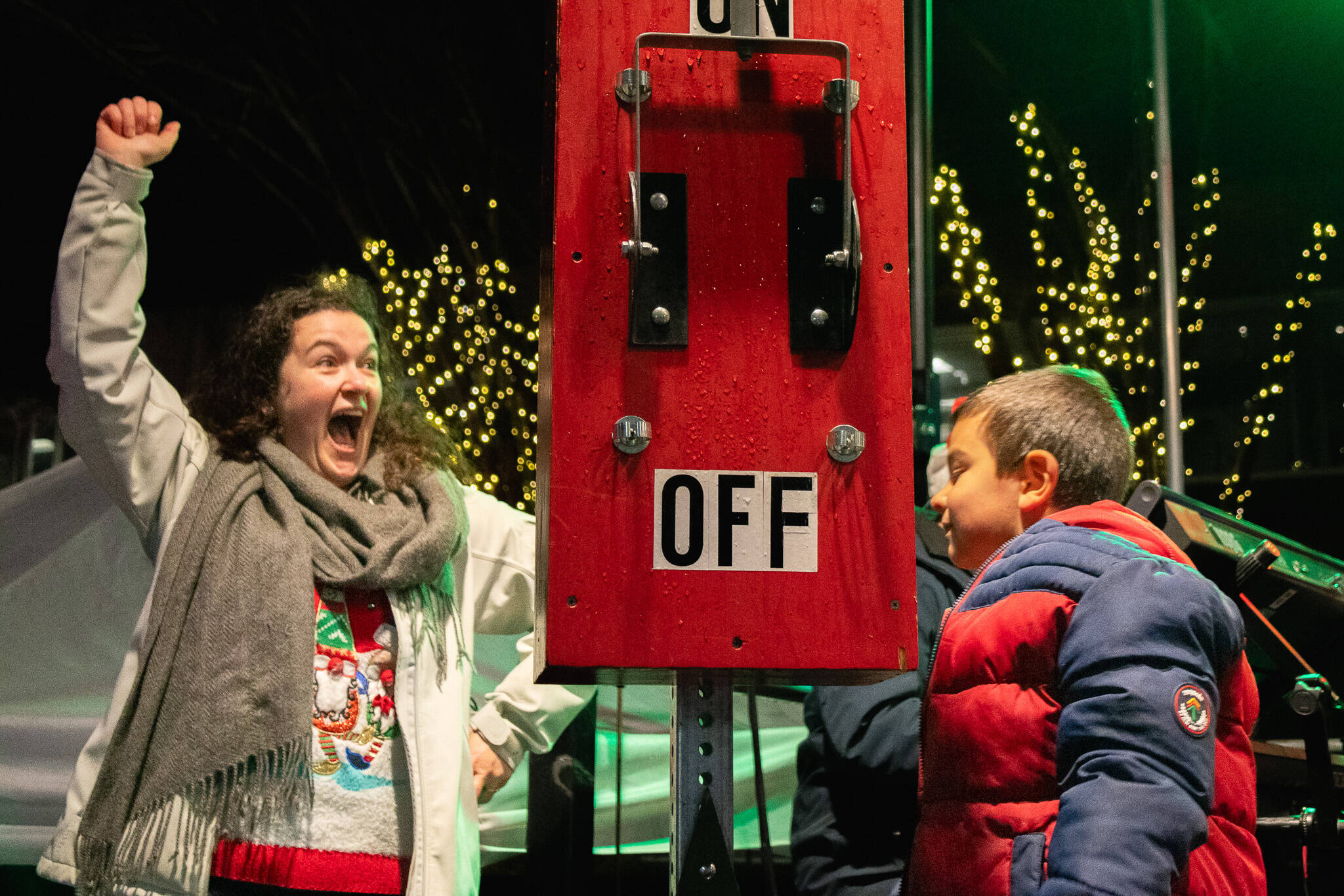 Flanking the oversized switch that lit the city’s Christmas tree are Michelle Heertje and her son, Elijah Rivera, the boy chosen to flip the switch on the stage in front of City Hall.
