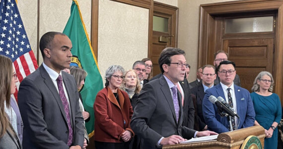 Gov. Bob Ferguson, surrounded by other state elected leaders, speaks at a Feb. 13 press conference in Olympia. (Photo by Bill Lucia/Washington State Standard)