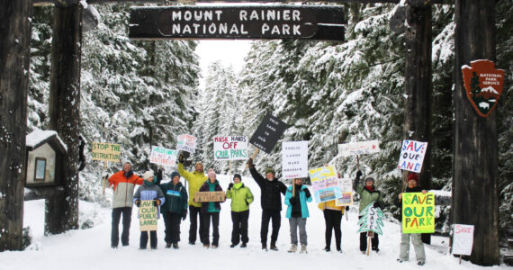 Eleven demonstrators cheered for the Forest Service and National Park Service under the enterence to Mount Rainier National Park last Saturday. All were local volunteers, and many said they hike local trails often, if not every day. Photos by Ray Miller-Still