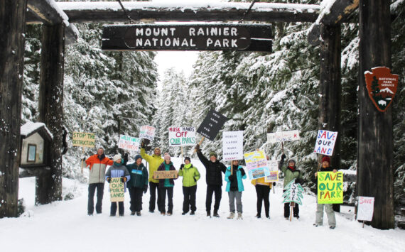 Eleven demonstrators cheered for the Forest Service and National Park Service under the enterence to Mount Rainier National Park last Saturday. All were local volunteers, and many said they hike local trails often, if not every day. Photos by Ray Miller-Still
