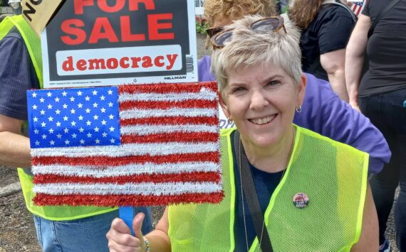 A former employee of the Auburn School District at the No Kings protest. Photo by Robert Whale/Auburn Reporter