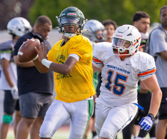 Auburn quarterback chased by Auburn Mountainview defender. Photo provided by Robby Mullikin.