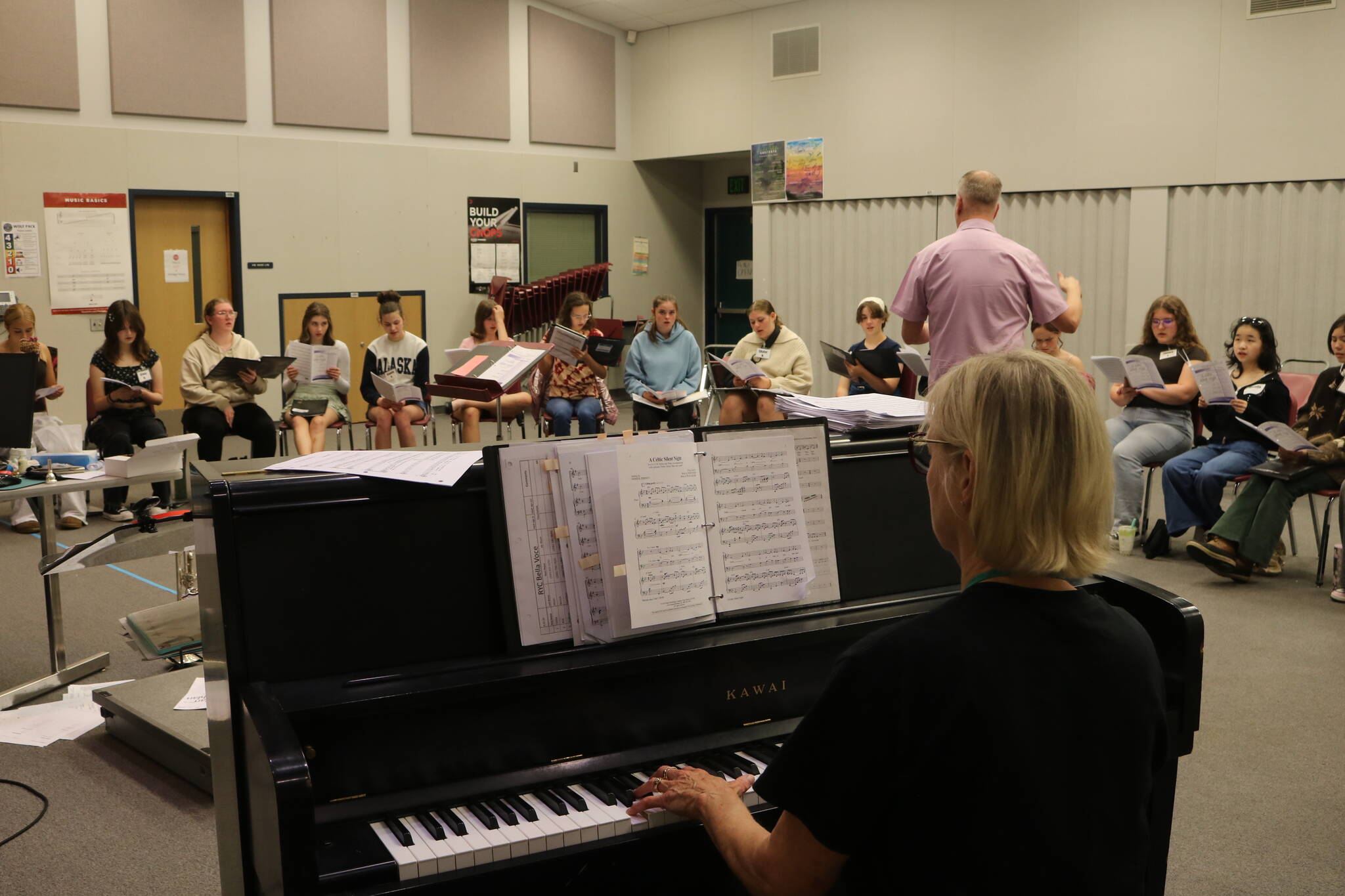 Rainier Youth Choirs founder Leora Schwitters plays piano as director Brian Hoskins leads the Consonore ensemble. Photo by Bailey Jo Josie/Sound Publishing.