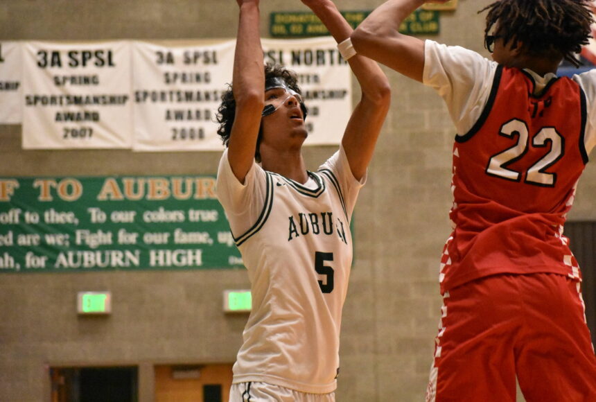 <p>Isaiah Englund holds the ball over his head against the Redhawks at Auburn High School. Ben Ray / The Reporter</p>