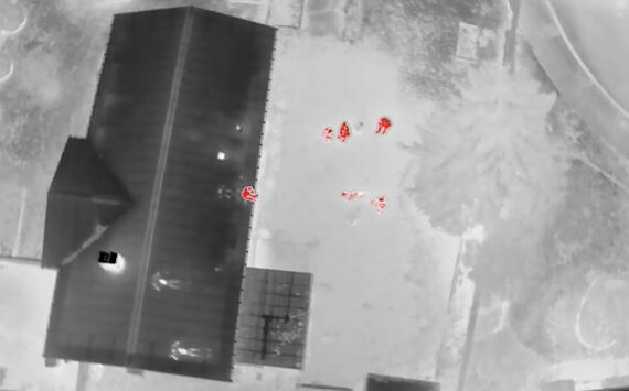 Drone thermal footage depicting the suspect sitting on the edge of the roof. Screenshot of Auburn police video.