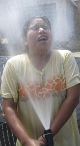 Maria Martin soaks herself with cold water during her church group's sponsored car wash in Auburn on Wednesday. Martin and her friends were washing vehicles to raise money for the Centro De Amistad Cristiano youth ministry. 'Today is much too hot