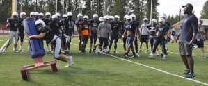 Auburn Riverside coach Bryant Thomas looks on as the Ravens go through a tackling drill.
