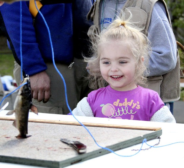 Lola Michelle Reagan watches as a Lions volunteer prepares to cleans her catch at last year's Special Needs Youth Fishing Derby at Auburn's Mill Pond Park.