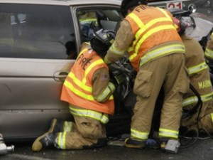 VRFA Firefighters attempt to remove a passenger from a smashed mini van involved in a head-on crash Monday on West Valley Highway North.