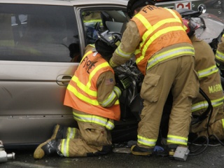 VRFA Firefighters attempt to remove a passenger from a smashed mini van involved in a head-on crash Monday on West Valley Highway North.