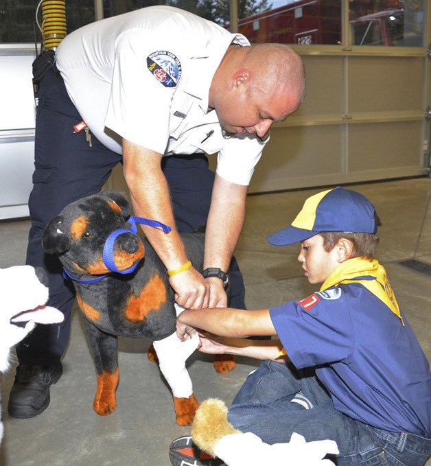 Firefighter Tim Perciful shows Cub Scout Gabriel Tinsley
