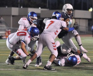 Auburn Riverside's O’Darious Shaw charges into the line against the Kent-Meridian defense during action Friday night.