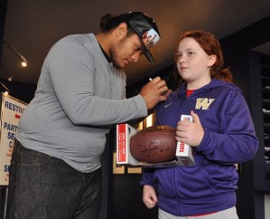 NFL defensive lineman Danny Shelton signs 12-year-old Emma McLaughlin’s jacket and gives her an autographed football during an appearance at Way Scarff Ford on Saturday.