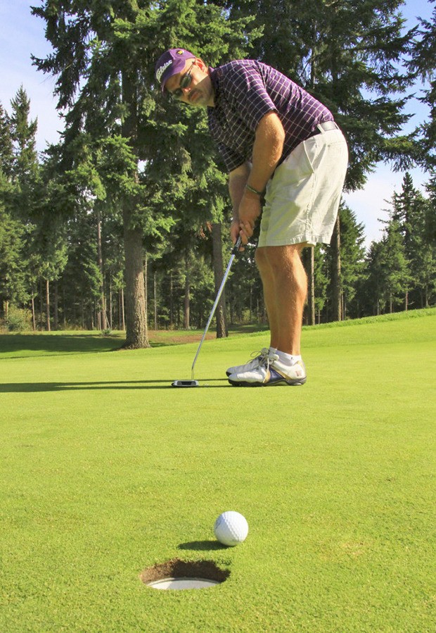 Rotarian Brett Cowman sinks a putt during the Earl Averill Invitational at Washington National.
