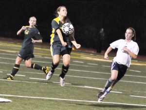 Auburn's Sadie Phonpadith pulls one down during Auburn's 1-0 win over district rival Auburn Riverside on Tuesday. Also pictured are Auburn's Chandler Johnson (12) and Riverside's Lauren Johnson.