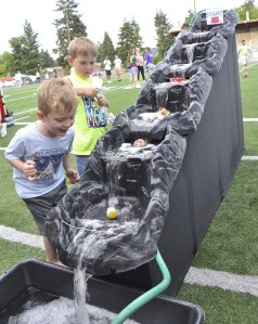 Kyle Davenport and Rowan Philps watch a duck race during the American Cancer Society's Auburn Relay for Life fundraiser at Auburn Memorial Stadium this weekend.