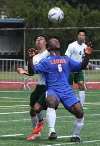 Lion junior Emmanuel Saah fights off a Foss player for control of the ball.