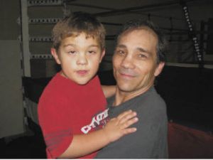 Former world champion boxer Greg Haugen holds his autistic grandson