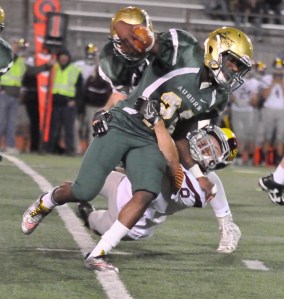 Auburn’s Joseph Fagan tries to power over Enumclaw’s Bryson Engebretsen during NPSL 4A play Friday night. Fagan ran for a school-record 288 yards and four touchdowns for the Trojans. RACHEL CIAMPI