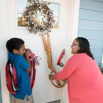 Rachel Grinage, a decorated U.S. Navy veteran, and a single mother, cuts the ribbon to her new home in Pacific with her 9-year-old son, Ahmad, during a dedication ceremony last Friday. COURTESY PHOTO